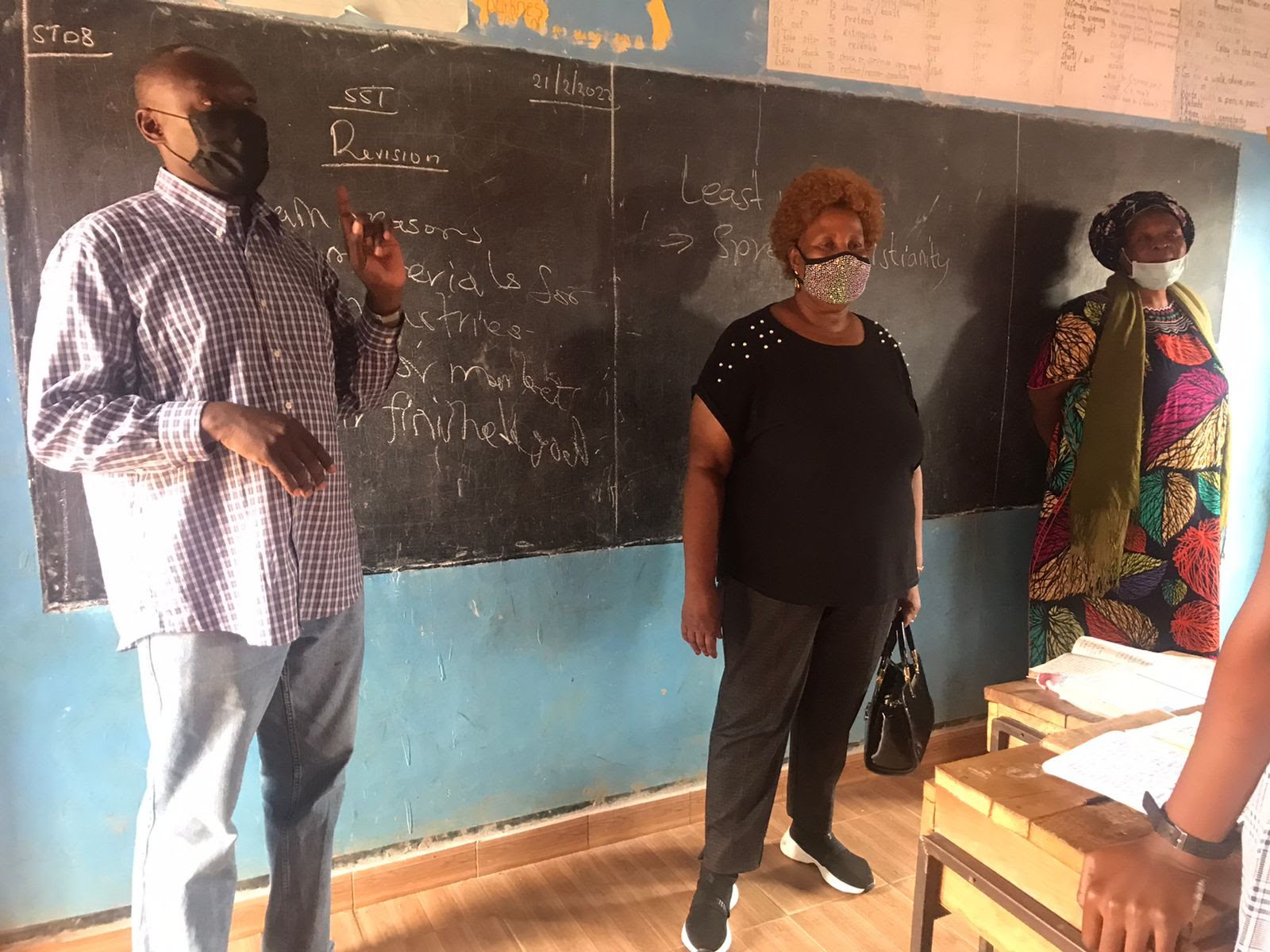 A group of people standing in front of a blackboard.