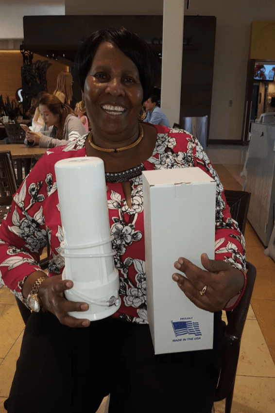 A woman sitting in a restaurant holding two boxes.